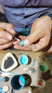 travail sur petit pendentif rond dans l'atelier